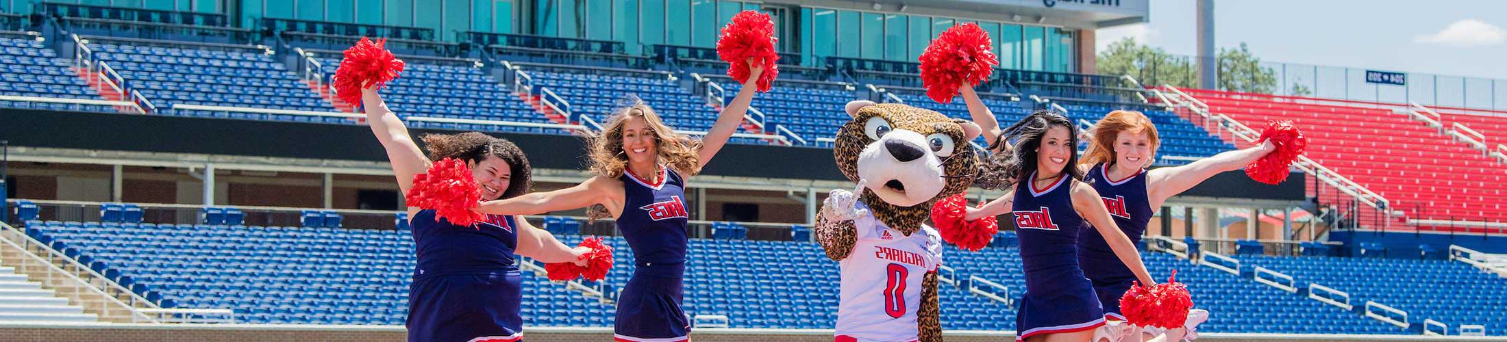 Southpaw with the cheerleaders on the football field.